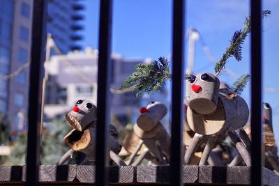Close-up of stuffed toy by window against sky