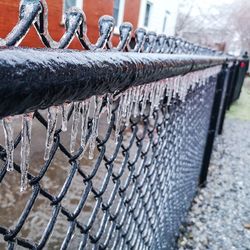 Close-up of barbed wire fence during winter