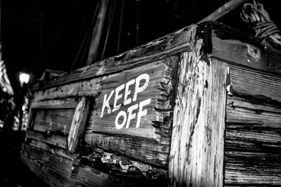 Low angle view of old sign at night