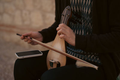 Midsection of man playing guitar