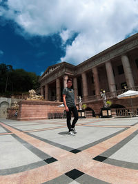 Full length portrait of man against historic building in city