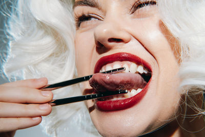 Close-up of young woman applying make-up