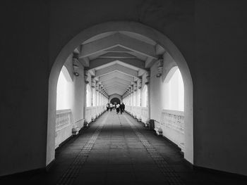 Rear view of people walking in corridor of building