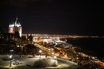 Illuminated cityscape against sky at night