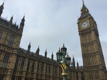 Low angle view of clock tower amidst buildings in city