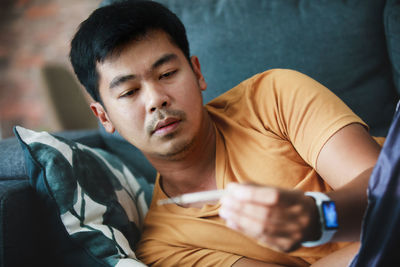 Portrait of young man sitting on sofa