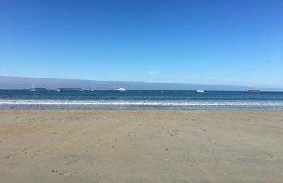 Scenic view of beach against clear blue sky