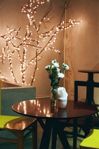 Flower vase on table at illuminated restaurant