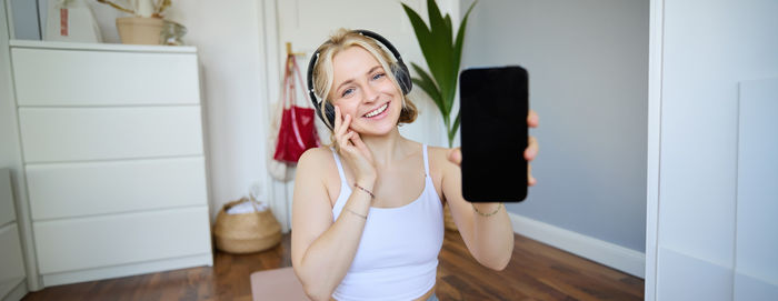 Young woman using mobile phone at home