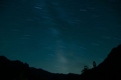 Low angle view of silhouette star field against sky at night