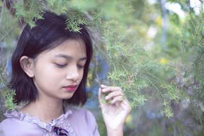 Portraits lonely young girl with pine tree background in vintage color.