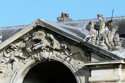 Low angle view of sculptures on building against sky