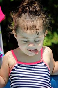 Close-up of baby girl sticking out tongue