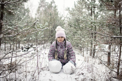 Portrait of young woman sitting on tree