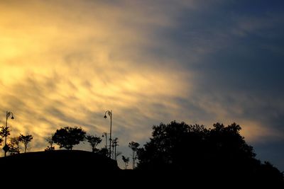 Low angle view of silhouette trees against sky at sunset