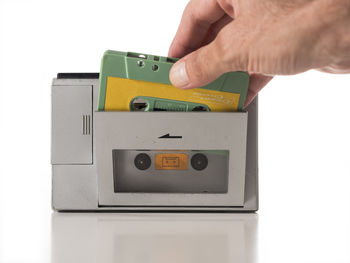 Close-up of hand holding toy against white background