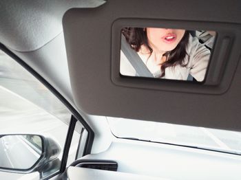 Woman using smart phone in car