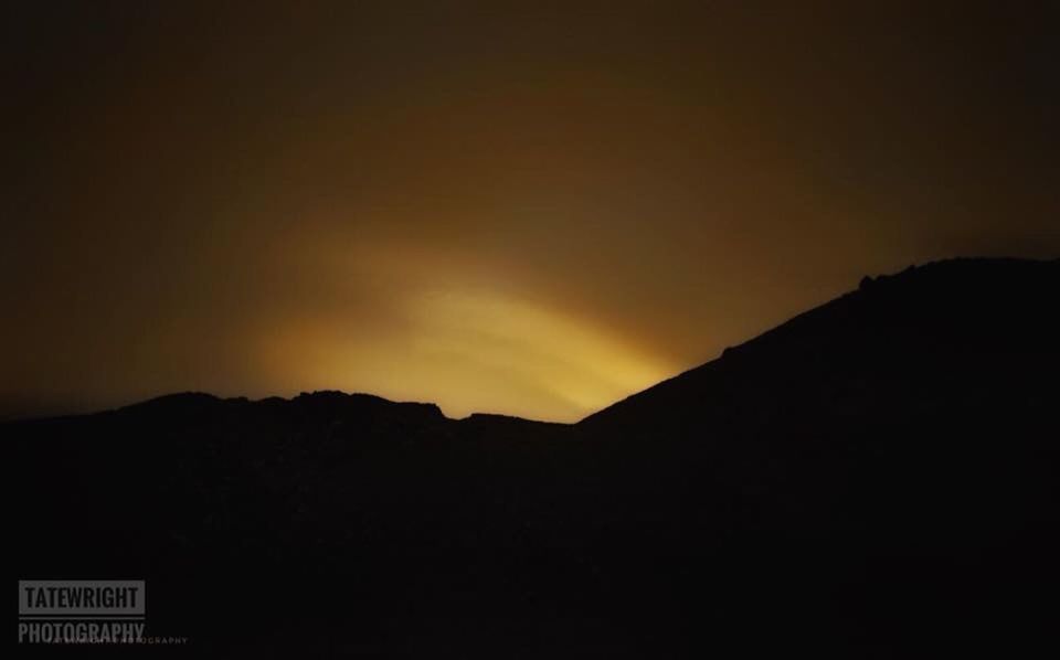 SILHOUETTE MOUNTAINS AGAINST SKY AT NIGHT