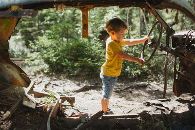 Boy playing in wrecked car