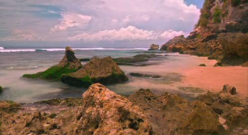 Scenic view of rocks on beach against sky