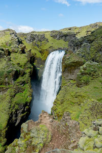 Scenic view of waterfall against sky