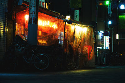 Bicycle on road against buildings in city at night