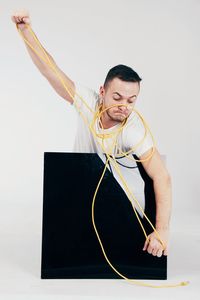 Young man looking away against white background