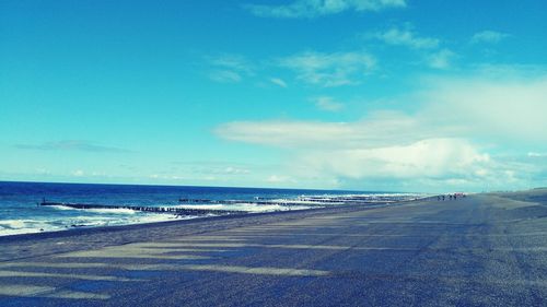 Scenic view of beach against blue sky