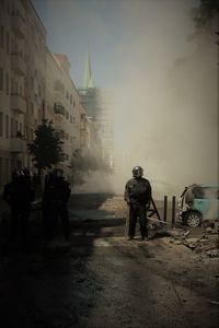 People standing on street against buildings in city