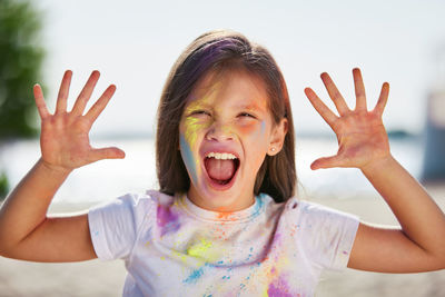 Portrait of young woman gesturing against sky