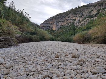 Surface level of stones on land against sky