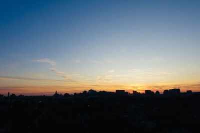 Silhouette buildings against sky during sunset