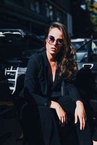 Young woman wearing sunglasses while sitting in car