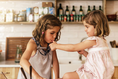 Girl and woman standing at home