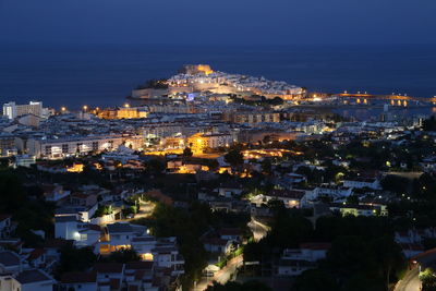 Illuminated peniscola by sea at night