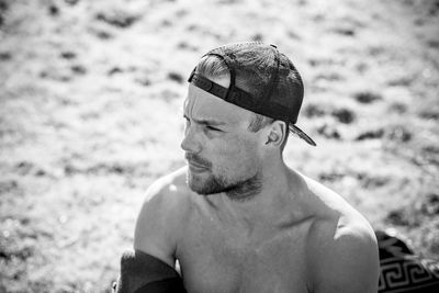 Shirtless man wearing cap at beach