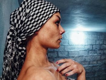 Close-up portrait of a young woman against wall