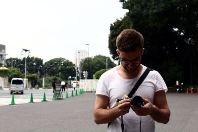 Young man using mobile phone in city