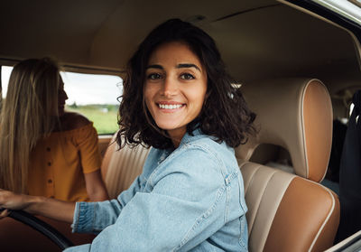 Portrait of smiling young woman sitting in car