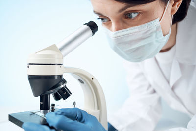 Doctor looking through microscope