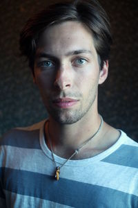 Close-up portrait of young man standing against wall