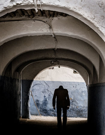 FULL LENGTH REAR VIEW OF SILHOUETTE MAN STANDING IN BUILDING