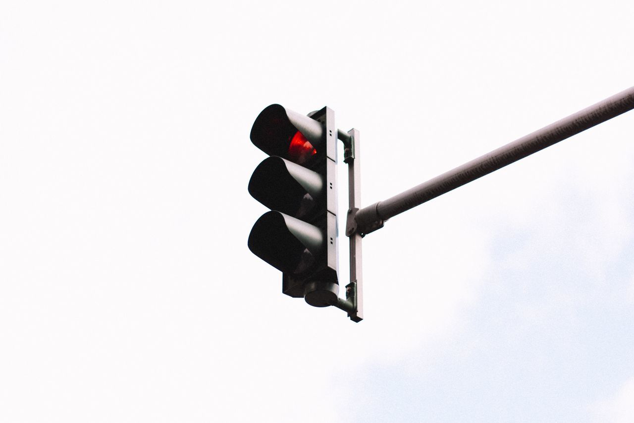 low angle view, red, red light, lighting equipment, clear sky, no people, stoplight, outdoors, illuminated, signal, sky, day, nature, traffic signal