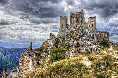 Silhouette of castle against cloudy sky
