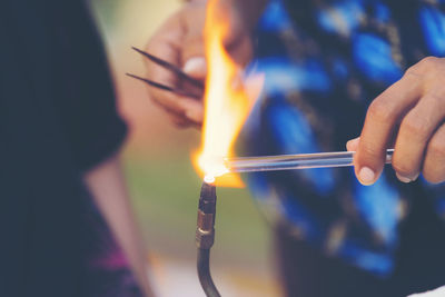 Close-up of hand holding burning candle