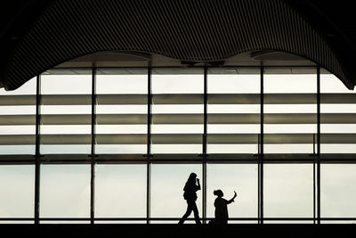 Silhouette people walking at airport