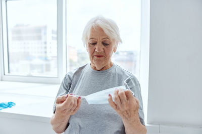 Midsection of woman holding paper at home