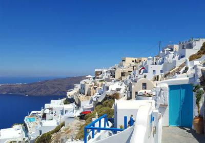 View of buildings in city against blue sky