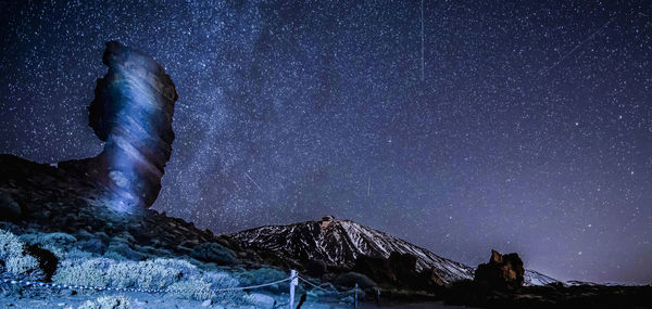 Scenic view of illuminated mountain against sky at night