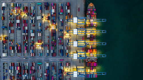 Aerial view container ship loaded in container terminal at night, global business import export 